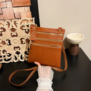 Brown leather crossbody bag with multiple zipper pockets for daily use detail view