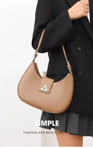 Detail view of a stylish khaki crescent shoulder bag featuring a unique metal triangle clasp.