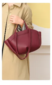 Détail du sac cabas en cuir rouge vin, offrant une grande capacité et de jolies poignées.