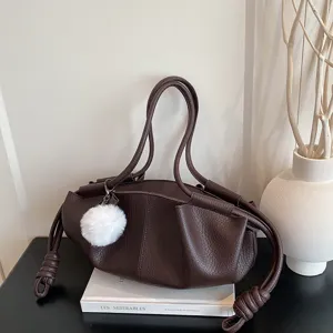 Dark brown soft leather shoulder bag with fluffy pom-pom pendant, stylish casual handbag for women.