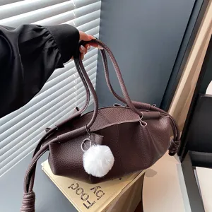 Stylish women's brown soft leather shoulder handbag with double handles and cute plush ball.