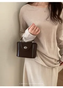 Brown structured box handbag with turn-lock closure, stylish retro chic commuter bag.