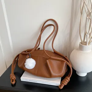 Brown soft leather shoulder bag with chic dumpling design and cute white plush pom pom.
