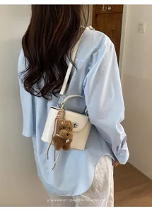 Stylish white crossbody box bag with cute puppy pendant, perfect for chic daily commuting style.