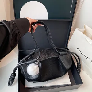 Black soft leather shoulder bag with knot handle and fluffy pom-pom charm for women stylish.
