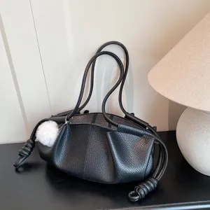 Close-up detail of a black soft leather shoulder bag with cloud pleats and knotted handles.