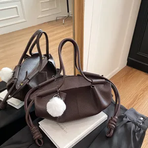 Brown soft leather shoulder bag detail, stylish cloud handbag with plush ball pendant.