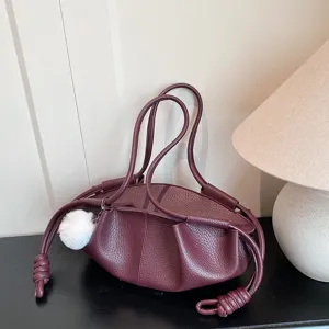 Burgundy leather shoulder bag with soft cloud shape, elegant knotted strap and plush charm detail.