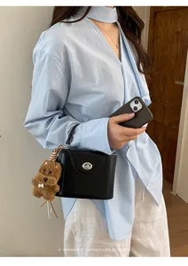 Black box handbag with twist lock and cute puppy charm, stylish and trendy detail view.