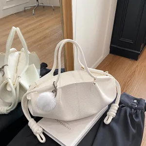 Details of the white soft leather cloud tote bag featuring stylish knotted straps and fluffy charm.