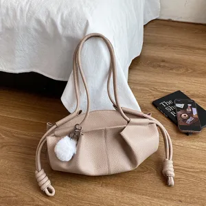 Stylish beige soft leather shoulder bag with knot details and fluffy plush pendant.