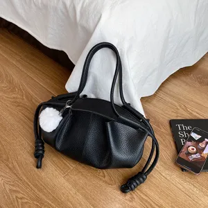 Black soft leather shoulder bag detail, stylish cloud handbag with plush charm and knot handle.