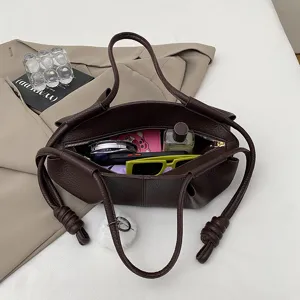 Dark brown soft leather shoulder bag for women, stylish cloud handbag with knot straps and charm.