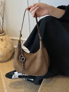 Stylish brown suede hobo shoulder bag for women, trendy commuter bag with chic pendant.