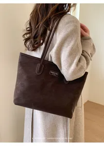 Detailed shot of the brown suede tote bag worn on shoulder, showcasing minimalist retro style.
