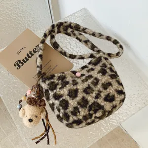 Close-up detail of fluffy leopard print shoulder bag with cute bear charm and soft plush texture.