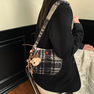 Detail view of the vintage plaid shearling shoulder bag with cute bear charm and thick strap.