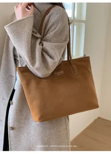 Close-up detail of vintage brown suede tote bag, showing premium texture and neat stitching.