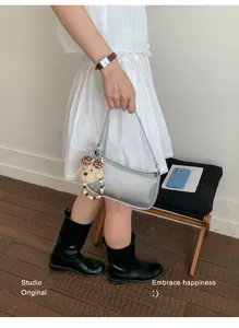 Minimalist metallic silver shoulder bag for women, chic underarm bag with cute bear charm.