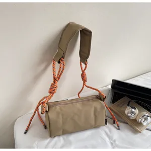 Casual khaki cylindrical shoulder bag with striking orange climbing rope straps for women.
