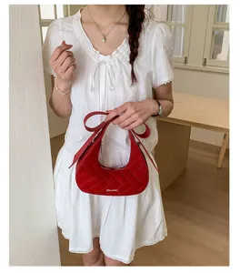 Red quilted hobo shoulder bag for women, stylish bow strap fashion handbag detail view.