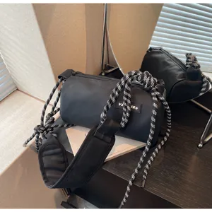 Black cylindrical shoulder bag with braided rope strap, stylish waterproof barrel bag for women.