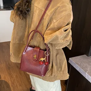 Retro dark red leather bucket bag for women, stylish casual shoulder and crossbody bag.