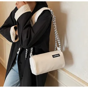 White cylindrical shoulder bag with braided rope strap and black label for women casual wear