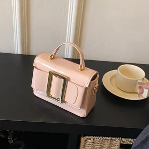 Chic pink patent leather handbag featuring a stylish metallic buckle and top handle design.