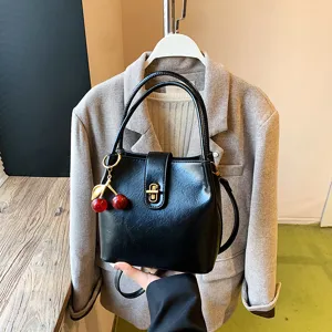 Stylish black PU leather bucket bag for women, retro shoulder crossbody bag with cute cherry charm.