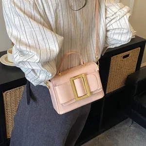 Trendy pink shoulder bag with elegant gold rectangular buckle and handle for women daily wear.