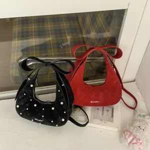 Stylish women quilted crescent shoulder bag with bow handle and elegant pearl decor.