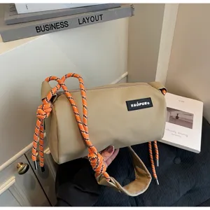 Stylish casual cylindrical shoulder bag featuring striking bright orange rope straps.