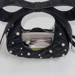 Black quilted shoulder bag for women with elegant bow and pearl embellishments, stylish design.
