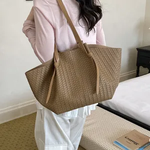 Detailed view of the brown woven tote bag, showcasing its large capacity and stylish design.