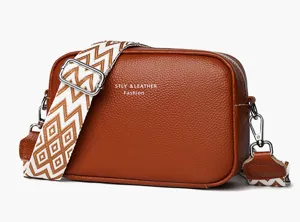 Genuine leather crossbody bag featuring wide geometric strap, multi-layer compact camera style.