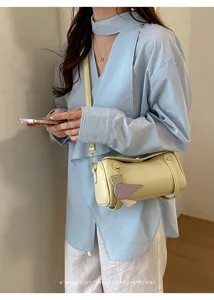 Borsa a tracolla cilindrica minimalista, borsa chic con ciondolo, stile estivo alla moda.