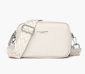 Close-up detail of the stylish beige leather cross-body bag with patterned wide strap detail.