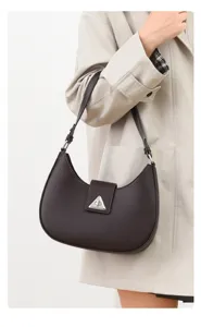 Detailed view of stylish brown crescent shoulder bag, minimalist daily accessory for women.