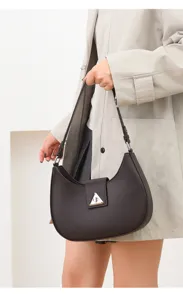 Detailed view of dark brown crescent shoulder bag with elegant triangle metal lock clasp.