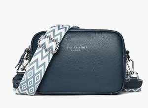 Dark blue leather crossbody bag with wide geometric strap and silver hardware detail.