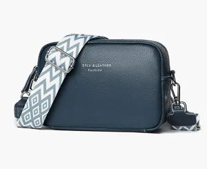 Leather crossbody bag for women, stylish camera bag with wide patterned strap and metal hardware.
