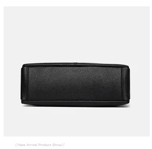 Black genuine leather handbag bottom detail showcasing high-end craftsmanship and cowhide texture.