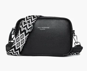 Black leather camera crossbody bag with wide patterned strap for women, stylish daily use.