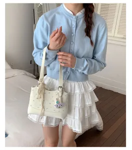 Detailed shot of Korean style white polka dot handbag with cute rabbit pendant and lace ribbon.