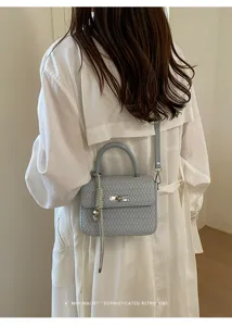 Bolso cruzado tejido minimalista con asa superior y elegante cierre de giro para uso diario.