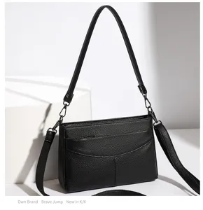Black genuine leather shoulder bag for women, stylish cowhide crossbody handbag detail.