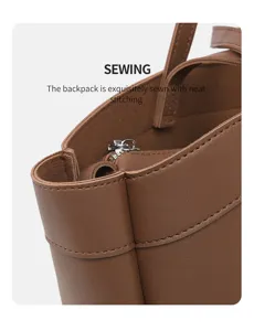 Detail de sac en cuir marron avec coutures raffinees et fermeture eclair metallique.