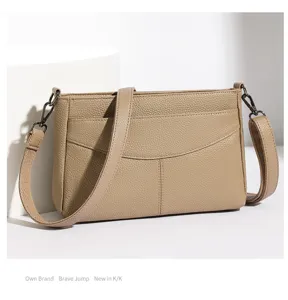 Detail view of pebble leather crossbody bag, adjustable strap and metal hardware.