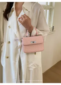 Chic bolso cruzado tejido rosa con asa superior y cerradura metálica de moda.
